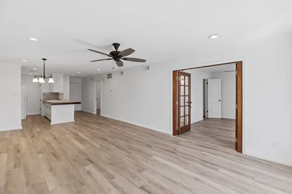 a view of empty room with wooden floor and ceiling fan