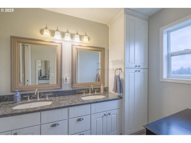 a bathroom with double vanity sinks and a mirror