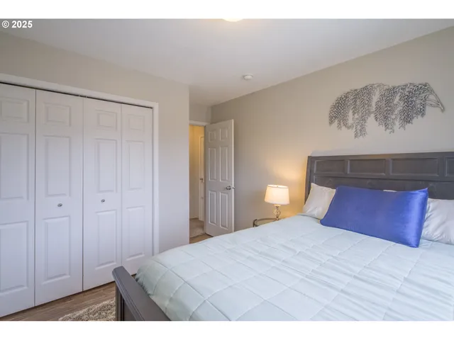 a bedroom with a bed and a painting on the wall