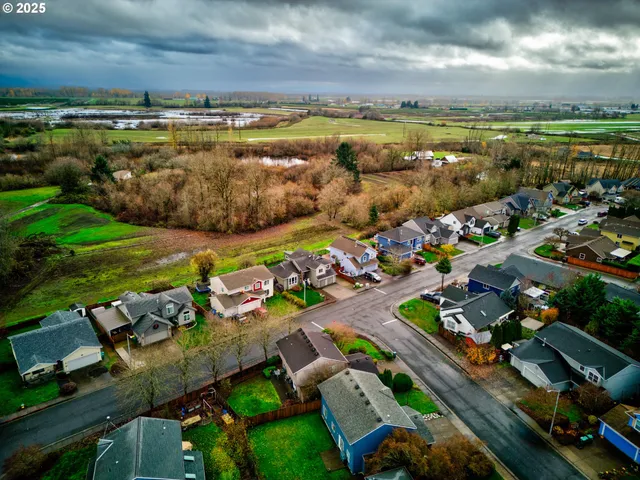 an aerial view of a city with lots of residential buildings ocean and mountain view in back