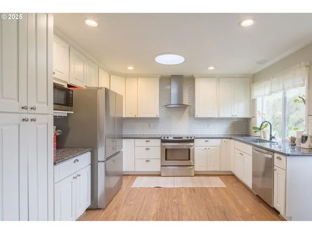 a kitchen with stainless steel appliances granite countertop a refrigerator sink and cabinets