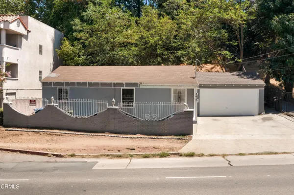 a front view of a house with a garden and garage
