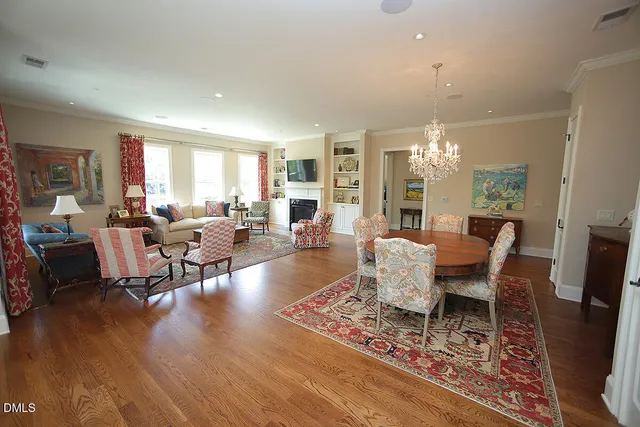 a living room with furniture a chandelier and a dining table