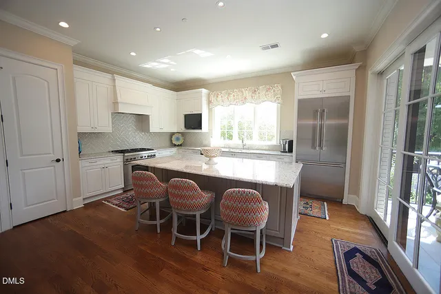 a kitchen with kitchen island granite countertop a sink cabinets and wooden floor