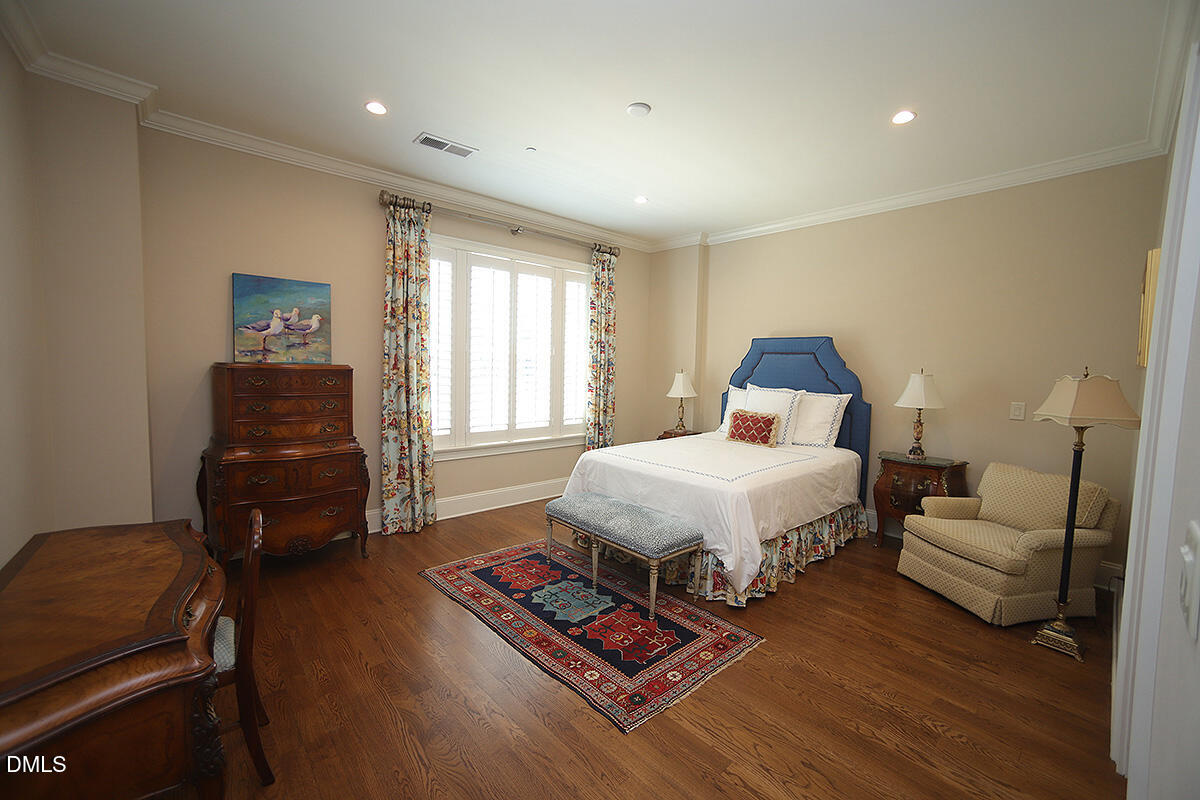 620 Wade Avenue, Unit 206 Raleigh, NC 27605 - Photo 30 of 42 a bedroom with a bed and wooden floor