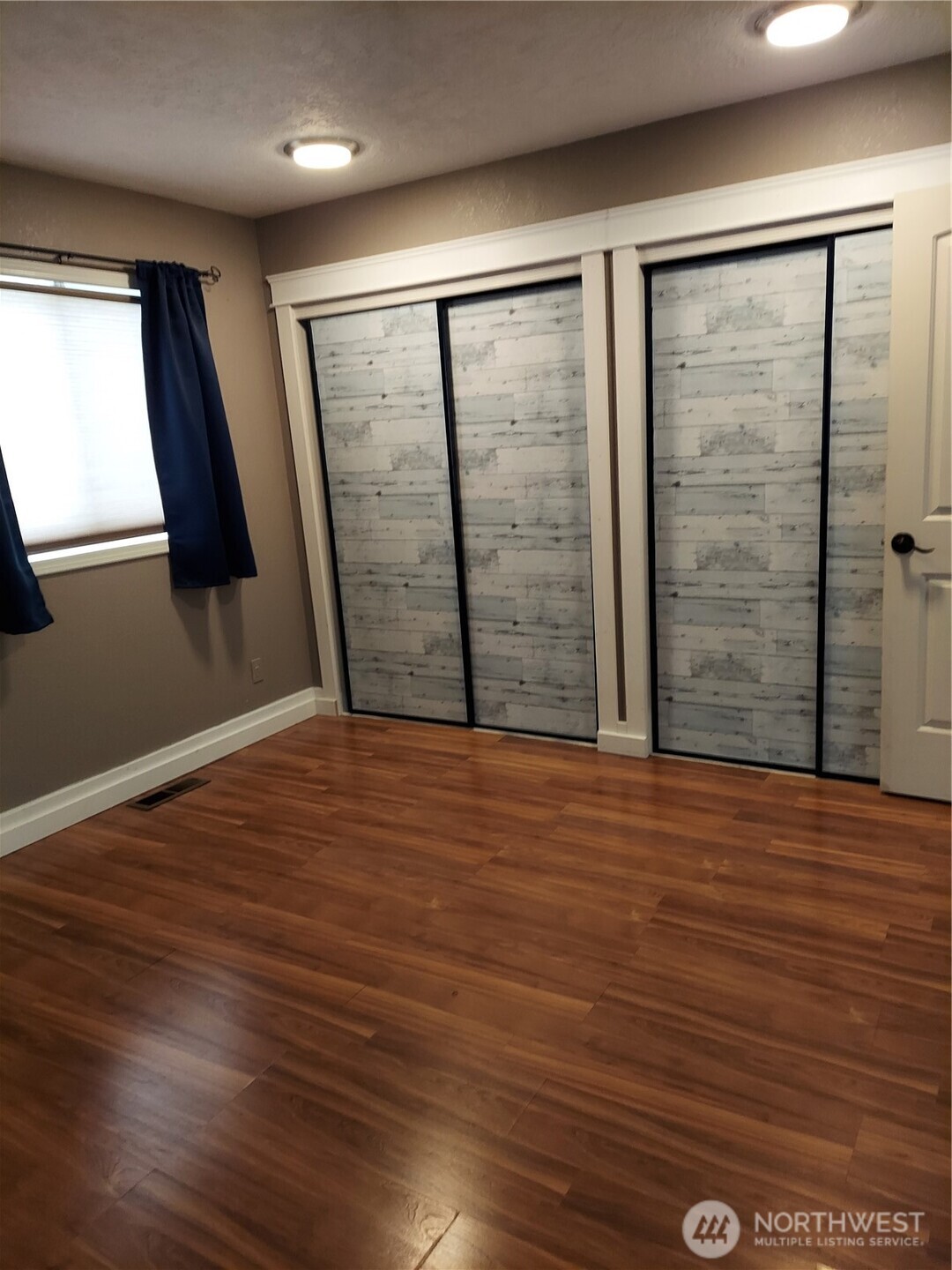 405 Strand Road Ephrata, WA 98823 - Photo 16 of 26 an empty room with wooden floor and sliding door