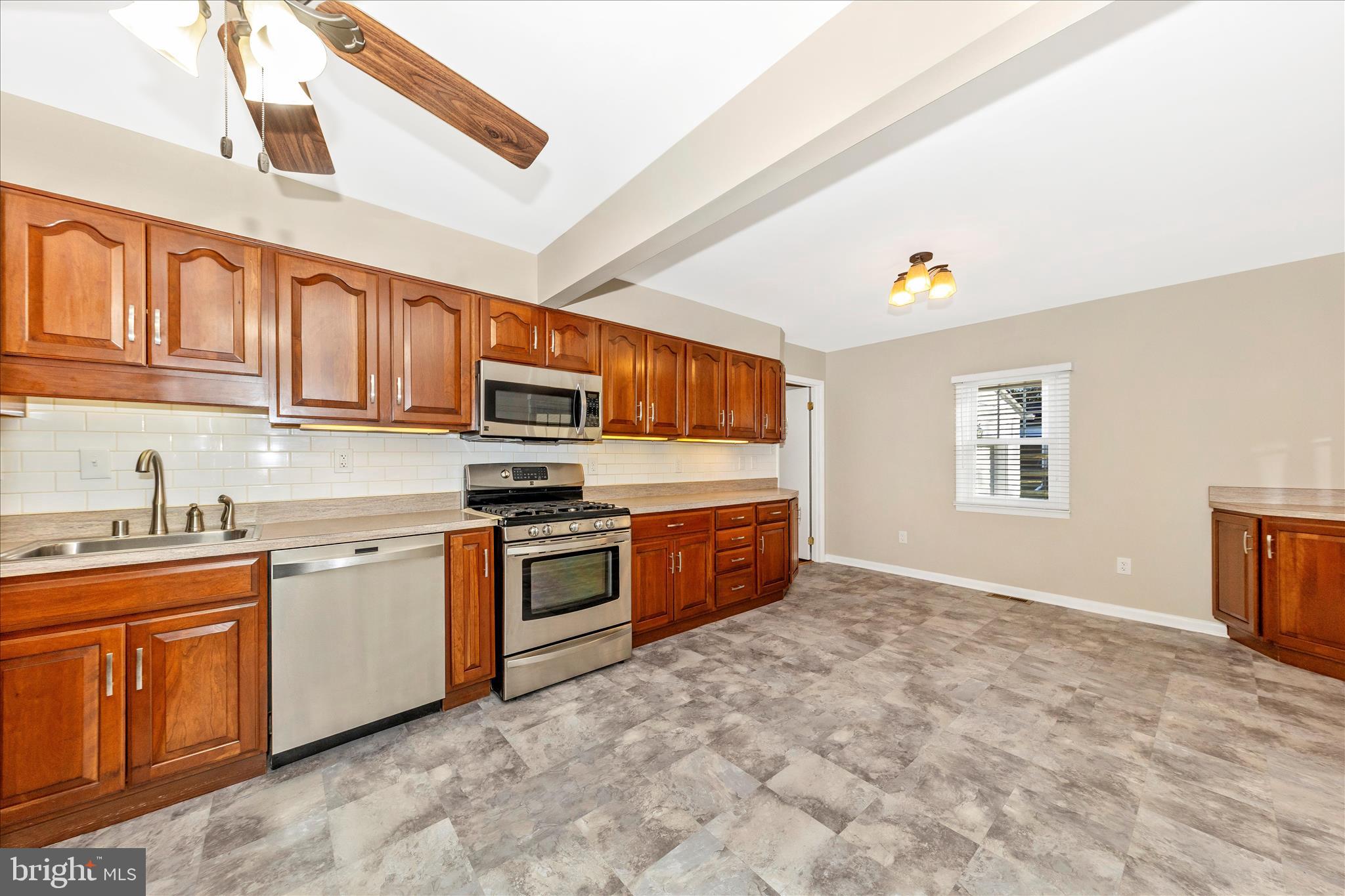 4410 Fernhill Road Silver Spring, MD 20906 - Photo 8 of 49 a kitchen with stainless steel appliances granite countertop a stove sink and cabinets