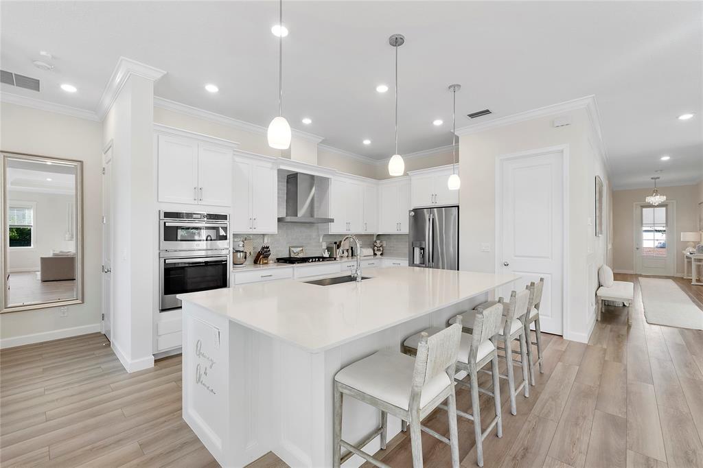 1131 Chisel Plow Chase Loxahatchee, FL 33470 - Photo 24 of 72 a kitchen with kitchen island a stove a table and chairs
