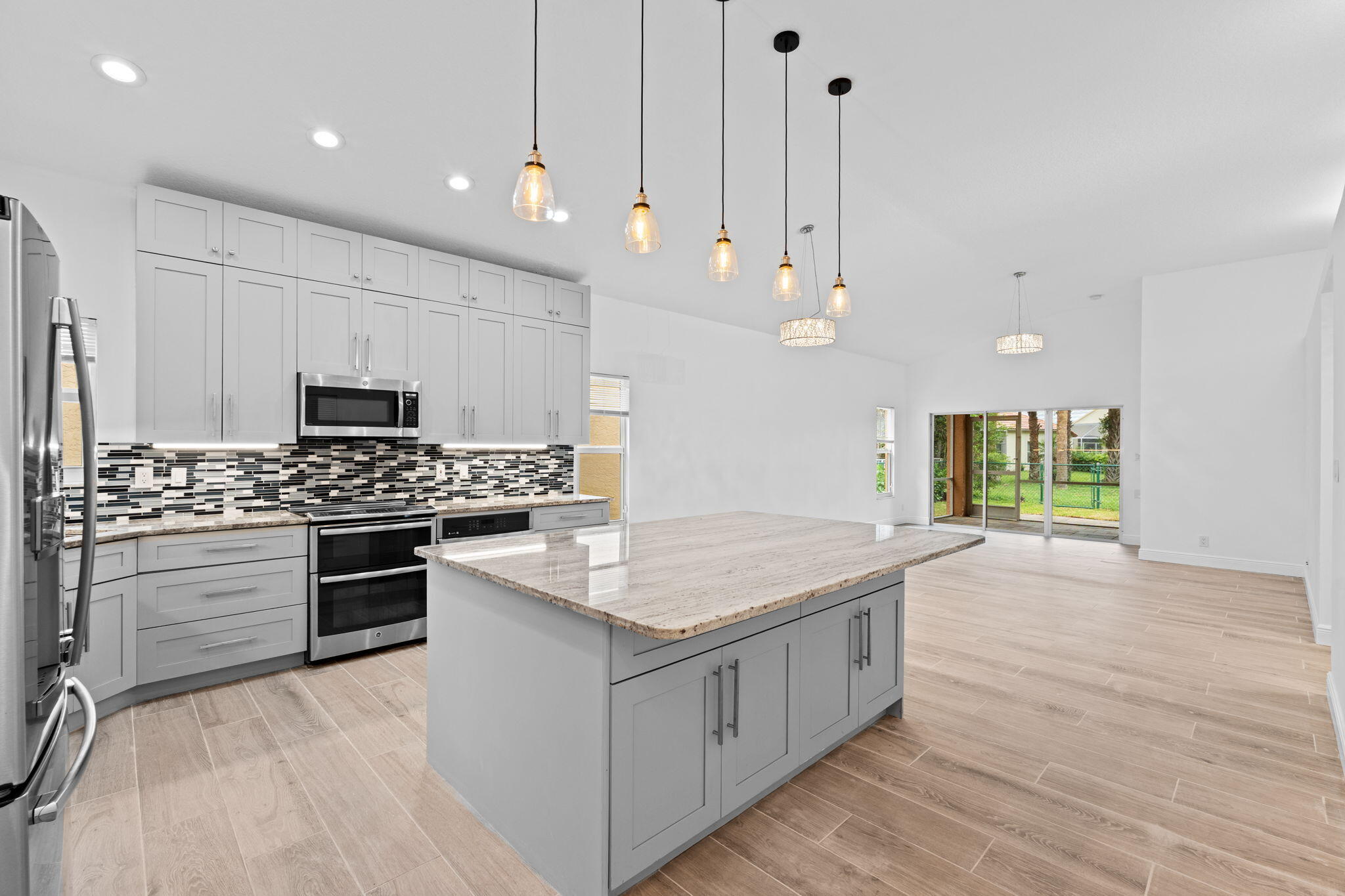 5122 Elpine Way Riviera Beach, FL 33418 - Photo 1 of 35 a kitchen with kitchen island a stove a sink and a refrigerator