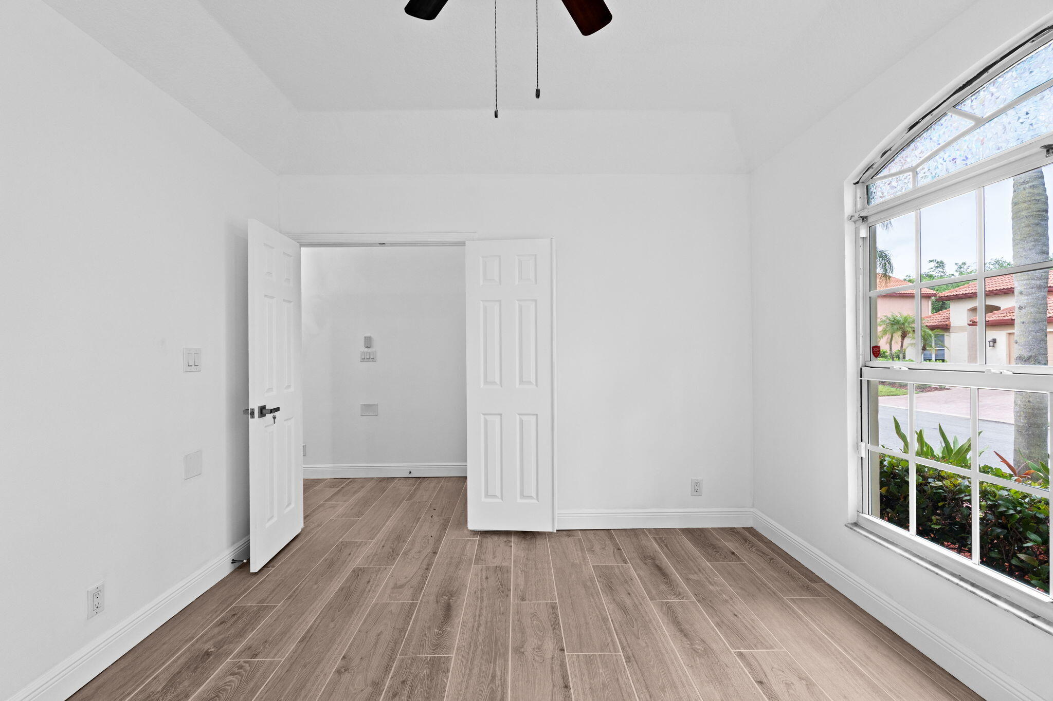 5122 Elpine Way Riviera Beach, FL 33418 - Photo 16 of 35 a view of an empty room with wooden floor and a window
