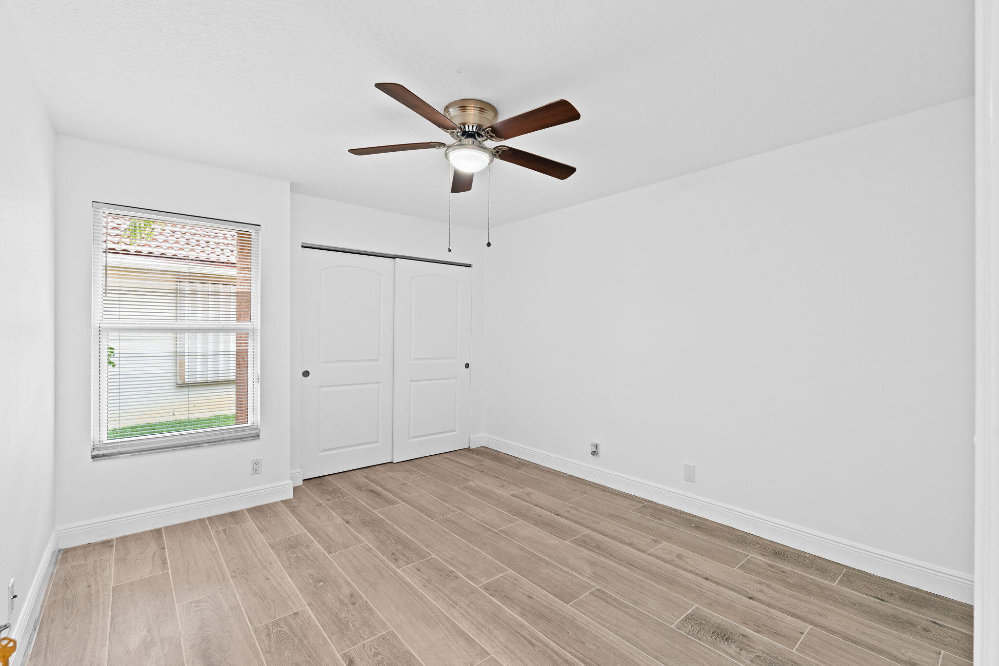 5122 Elpine Way Riviera Beach, FL 33418 - Photo 18 of 35 an empty room with a window and ceiling fan