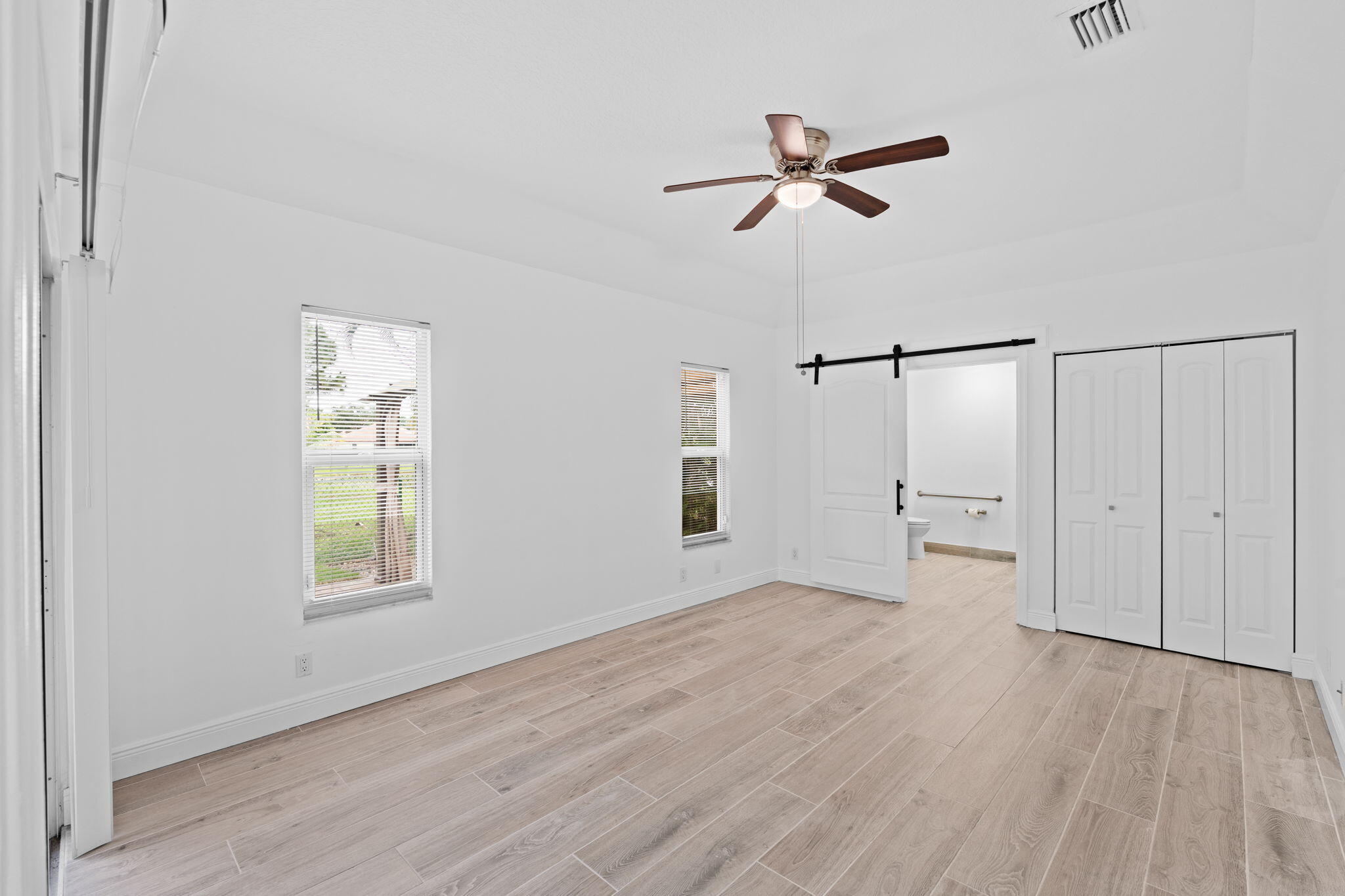 5122 Elpine Way Riviera Beach, FL 33418 - Photo 19 of 35 a view of a livingroom with a ceiling fan and wooden floor