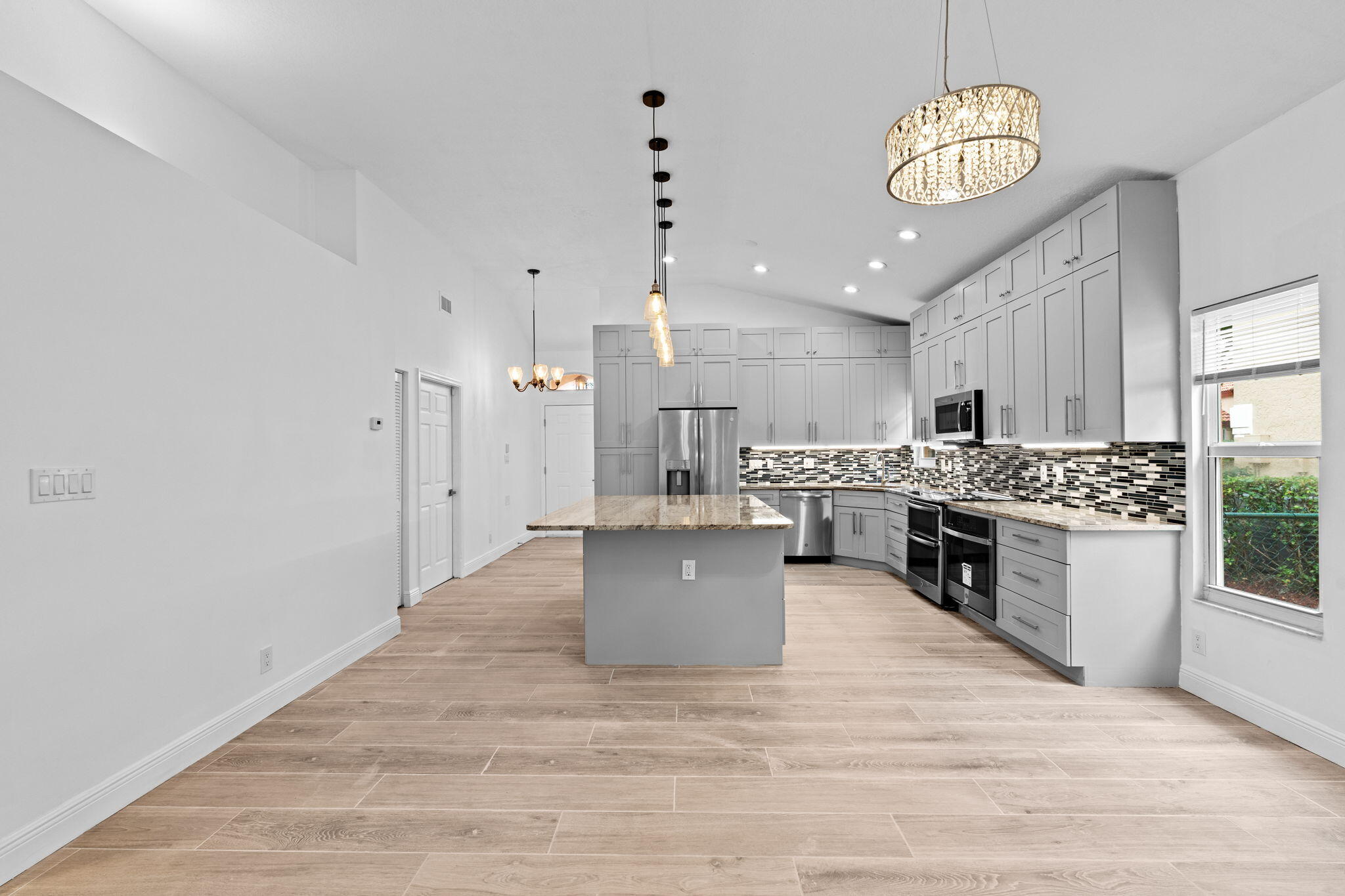 5122 Elpine Way Riviera Beach, FL 33418 - Photo 25 of 35 a large kitchen with a lot of cabinets and wooden floor