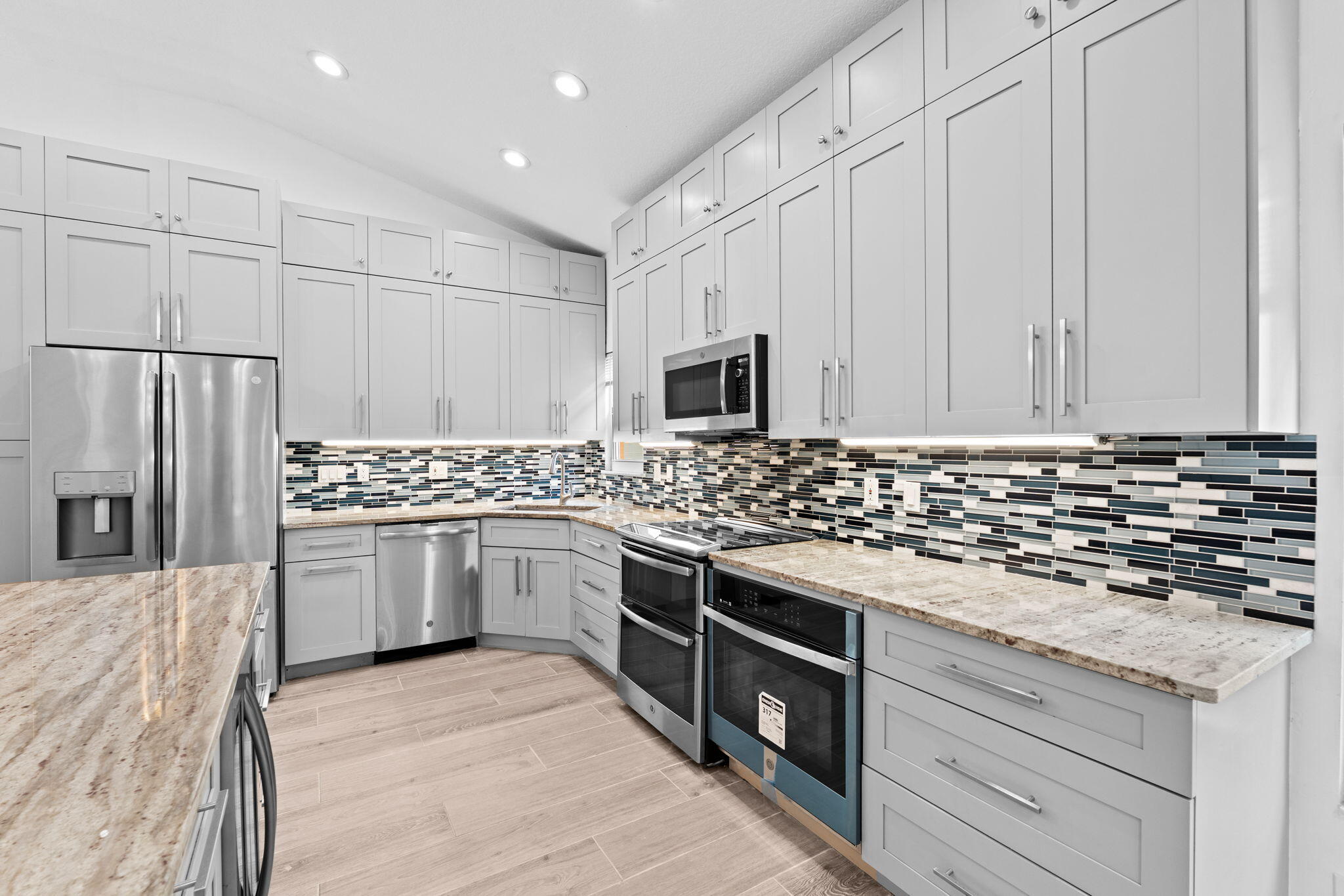 5122 Elpine Way Riviera Beach, FL 33418 - Photo 27 of 35 a kitchen with stainless steel appliances granite countertop a stove a sink and a refrigerator