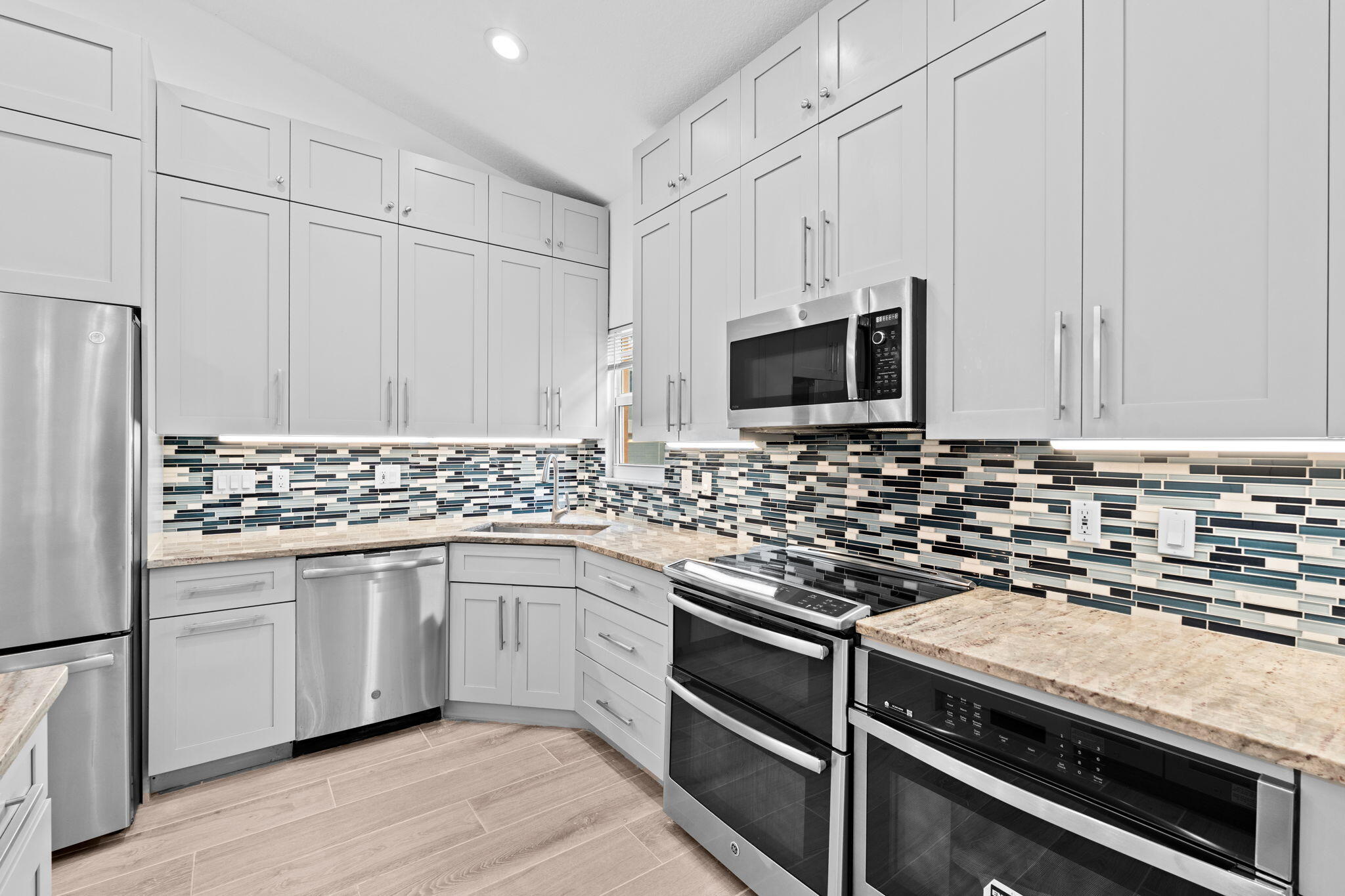 5122 Elpine Way Riviera Beach, FL 33418 - Photo 30 of 35 a kitchen with granite countertop a sink stove and microwave