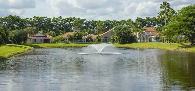 5122 Elpine Way Riviera Beach, FL 33418 - Photo 34 of 35 a view of pool with large trees and a big yard