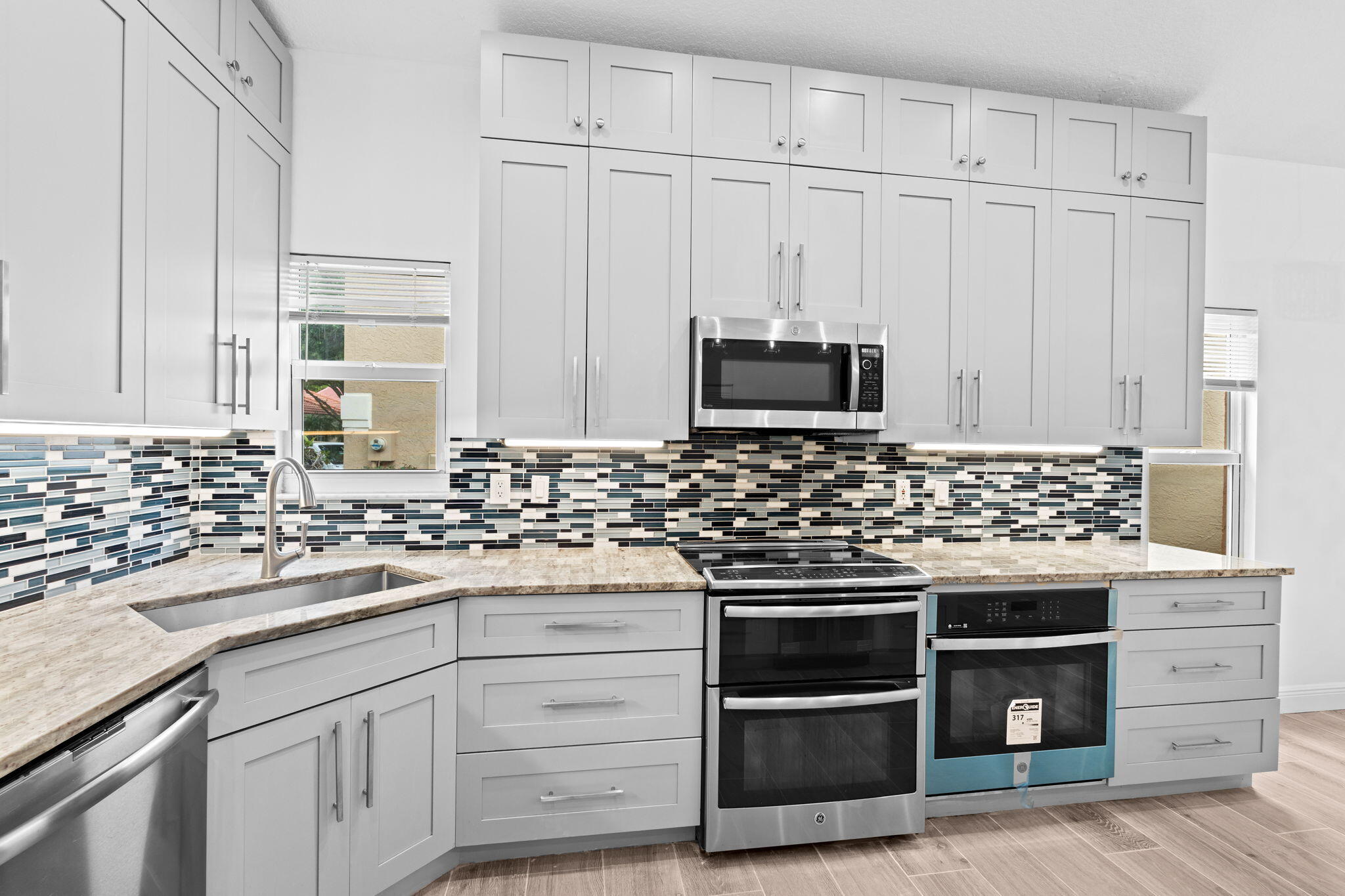 5122 Elpine Way Riviera Beach, FL 33418 - Photo 35 of 35 a kitchen with white cabinets and stainless steel appliances