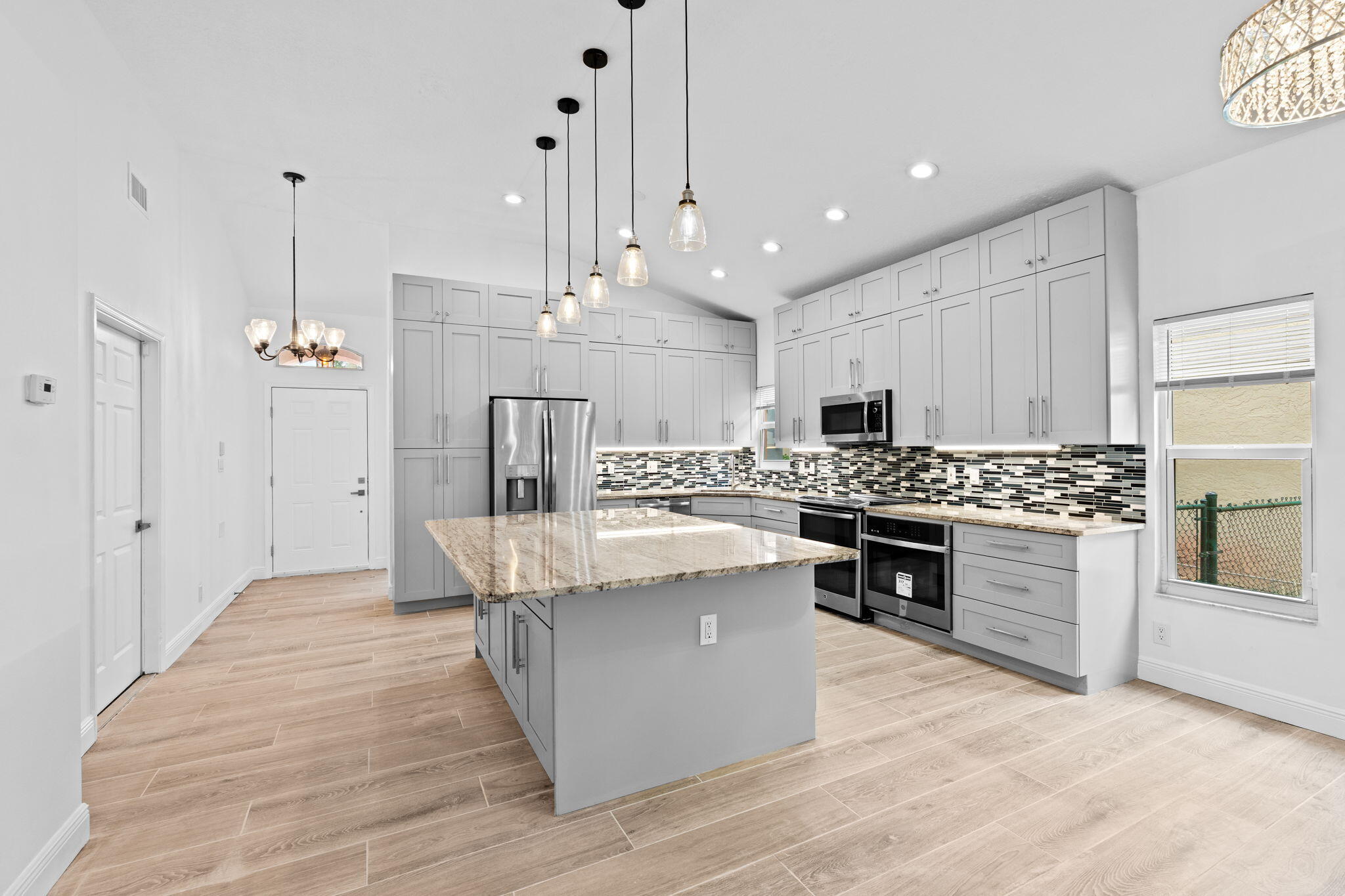 5122 Elpine Way Riviera Beach, FL 33418 - Photo 5 of 35 a large kitchen with stainless steel appliances kitchen island granite countertop a stove a sink a refrigerator and a wooden cabinets