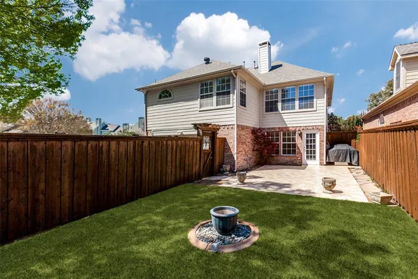a backyard of a house with table and chairs