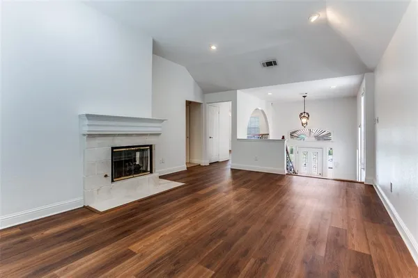 a view of empty room with wooden floor and fireplace