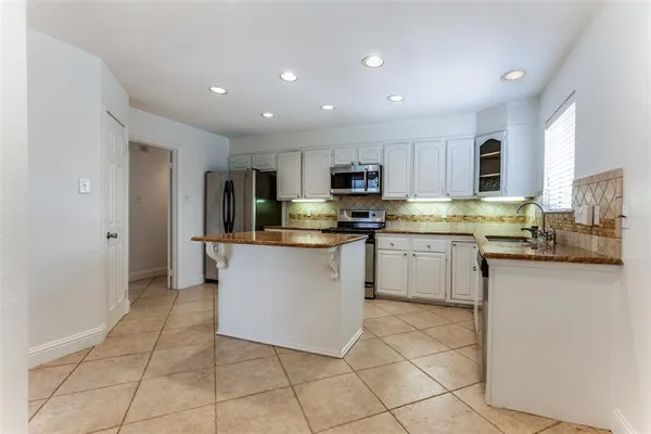 a kitchen with cabinets and stainless steel appliances