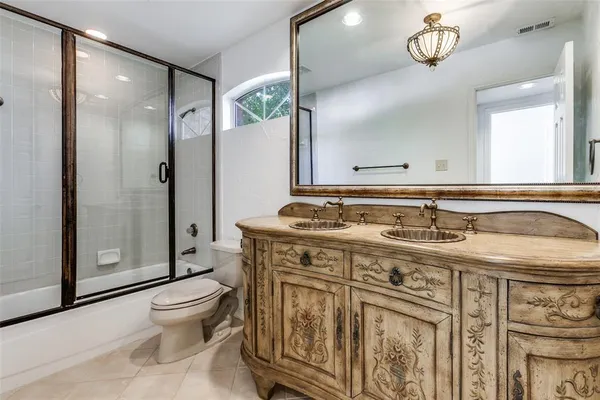 a bathroom with a sink a toilet a mirror and shower