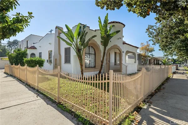 a view of a brick house with iron fence