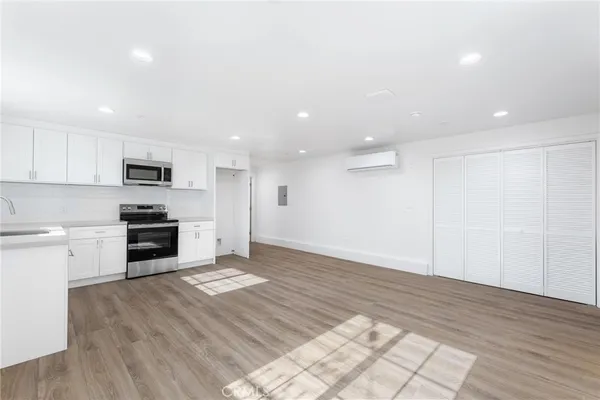 a kitchen with granite countertop a stove a sink and a refrigerator