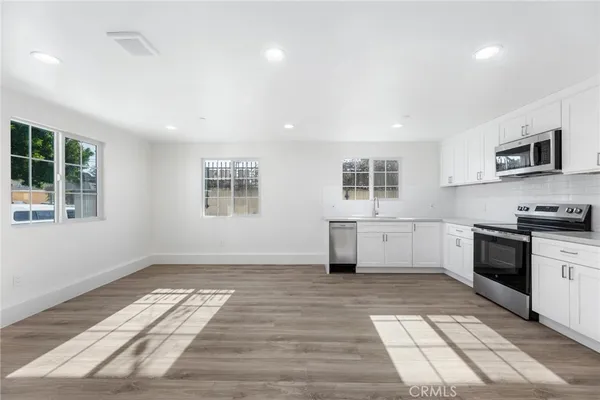 a kitchen with stainless steel appliances granite countertop a stove a sink and a microwave