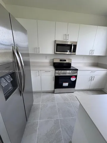 a kitchen with a sink a stove top oven and cabinets