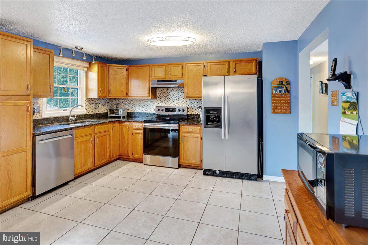 13226 Susquehanna Road Baltimore, MD 21220 - Photo 17 of 43 a kitchen with stainless steel appliances granite countertop a stove top oven a sink dishwasher and a refrigerator