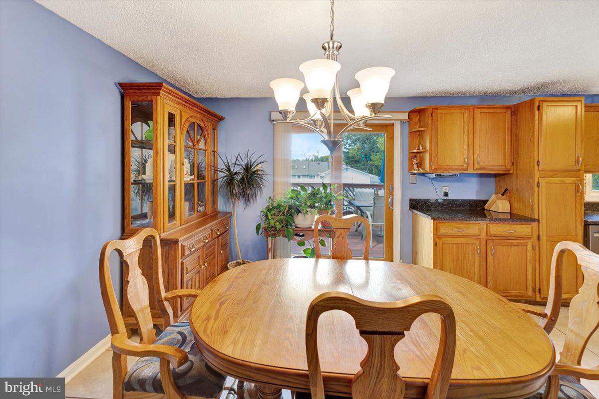 13226 Susquehanna Road Baltimore, MD 21220 - Photo 21 of 43 a view of a dining room with furniture a chandelier and large windows