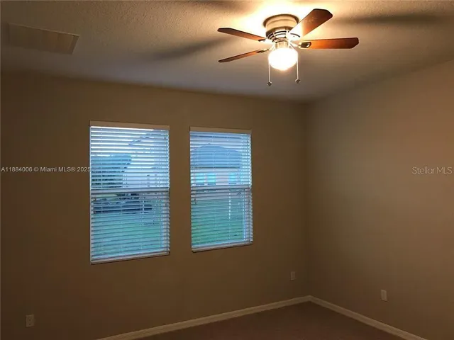 a view of a room has a window and a ceiling fan
