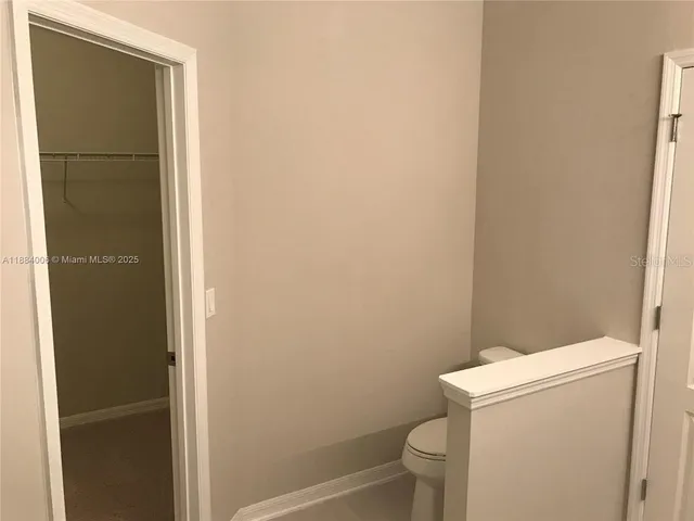 a white toilet sitting next to a shower