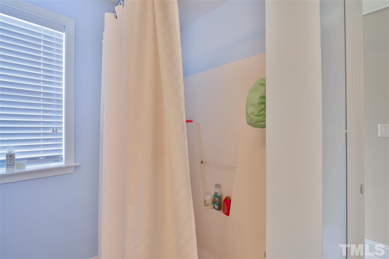 4415 Pike Road Raleigh, NC 27613 - Photo 13 of 19 a bathroom with a shower curtain and a window