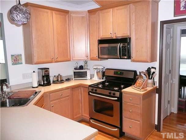 4415 Pike Road Raleigh, NC 27613 - Photo 4 of 19 a kitchen with stainless steel appliances a stove a sink and a microwave