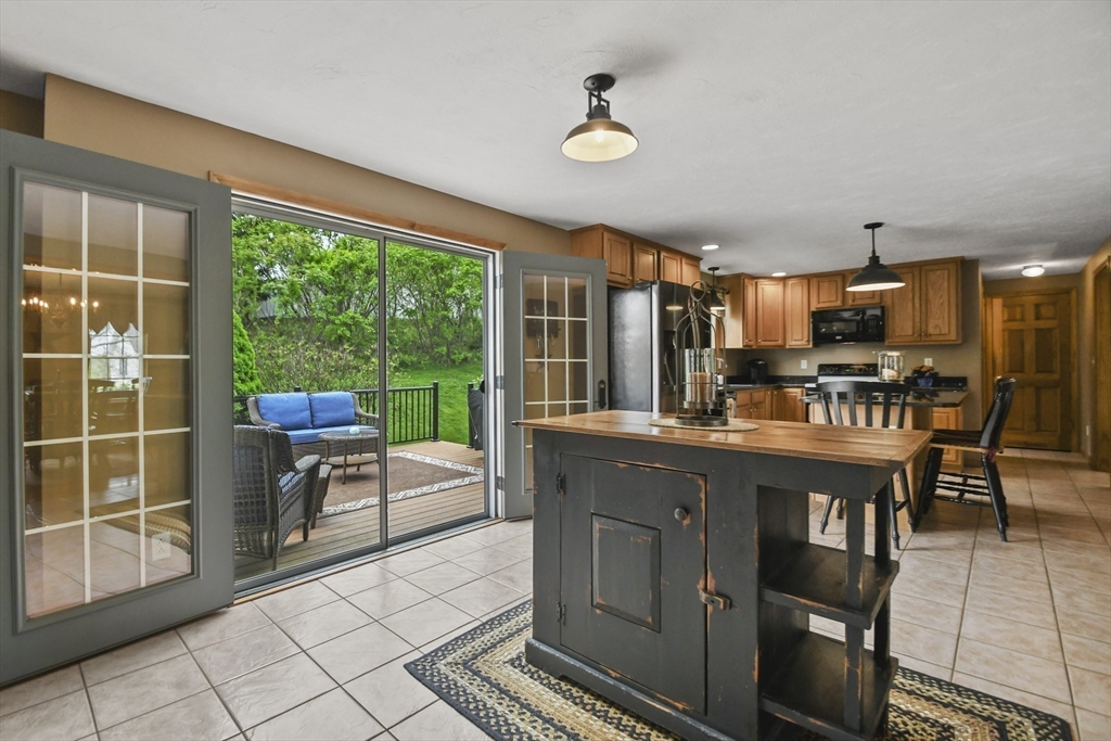 18 Jackson Avenue Rutland, MA 01543 - Photo 3 of 24 a kitchen with stainless steel appliances granite countertop a stove a sink dishwasher a dining table and chair with a large window