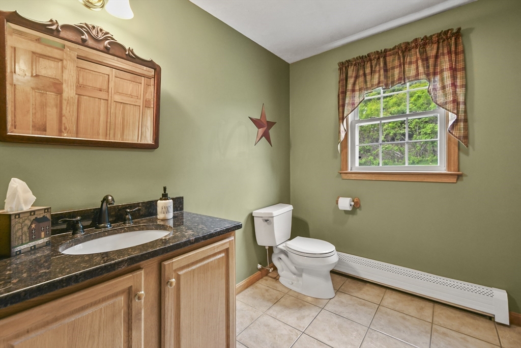 18 Jackson Avenue Rutland, MA 01543 - Photo 6 of 24 a bathroom with a granite countertop toilet a sink and a window