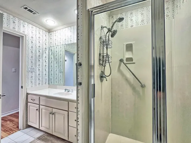 a bathroom with a double vanity sink mirror and shower