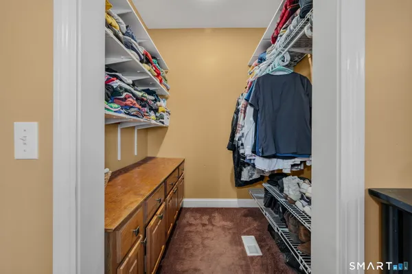 a view of walk in closet with clothes and shoes