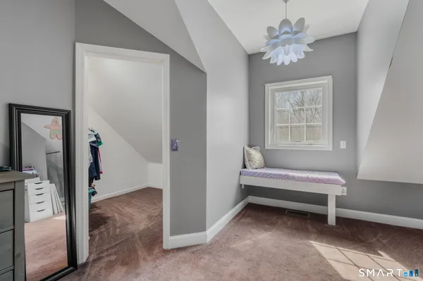 a spacious bedroom with a bed and a chandelier