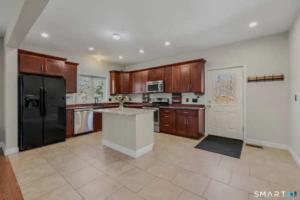 a kitchen with granite countertop a refrigerator and cabinets