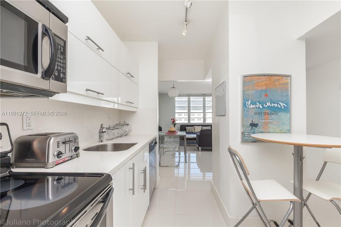 100 Lincoln Road, Unit 806 Miami Beach, FL 33139 - Photo 5 of 23 a kitchen with stainless steel appliances granite countertop a sink and cabinets