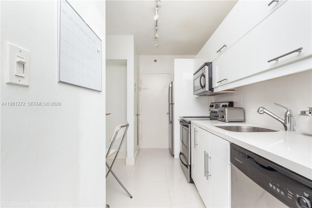 100 Lincoln Road, Unit 806 Miami Beach, FL 33139 - Photo 9 of 23 a kitchen with stainless steel appliances granite countertop a sink stove and refrigerator