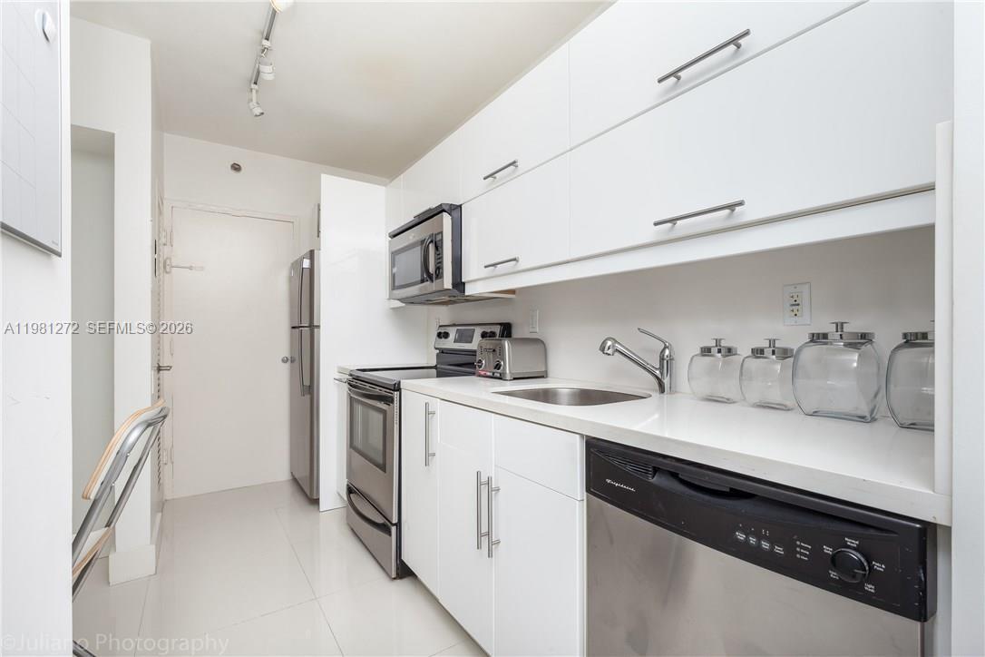 100 Lincoln Road, Unit 806 Miami Beach, FL 33139 - Photo 10 of 23 a kitchen with stainless steel appliances granite countertop a sink a stove a refrigerator and cabinets
