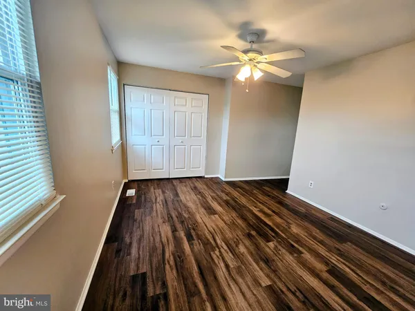 a view of a room with wooden floor staircase and a ceiling fan