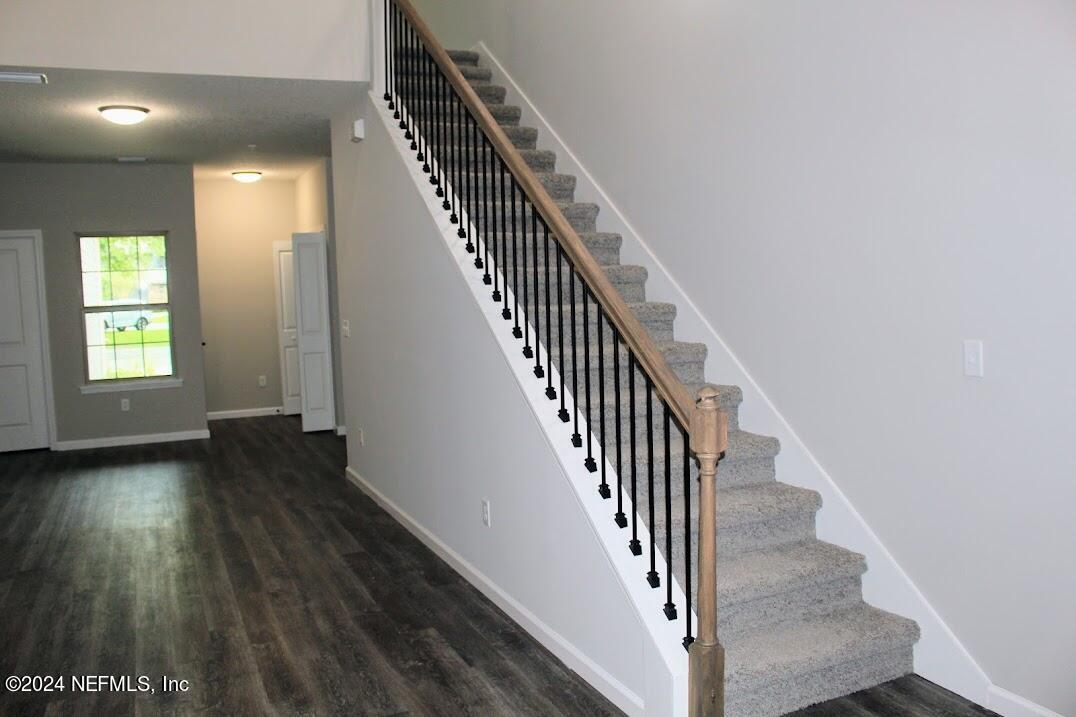 4146 Quiet Creek Loop, Unit 131 Middleburg, FL 32068 - Photo 12 of 39 an entryway in a hall with wooden floor and stairs