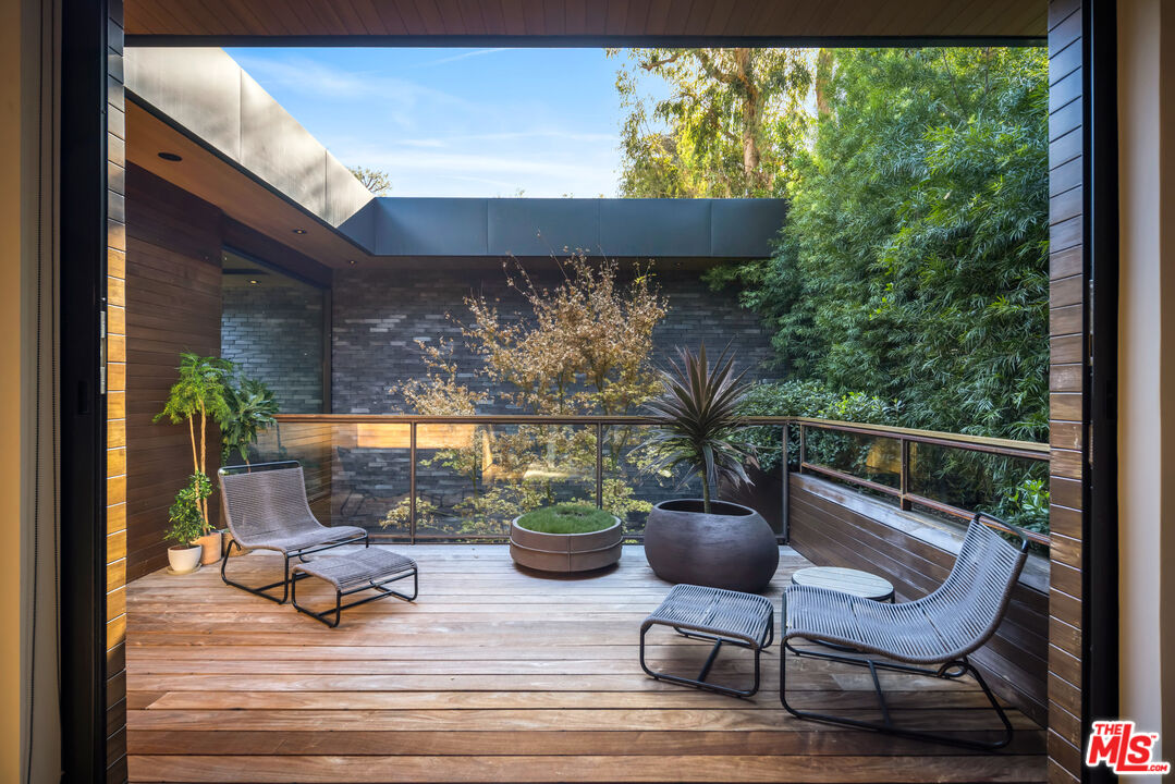 a view of a porch with chairs and a potted plant
