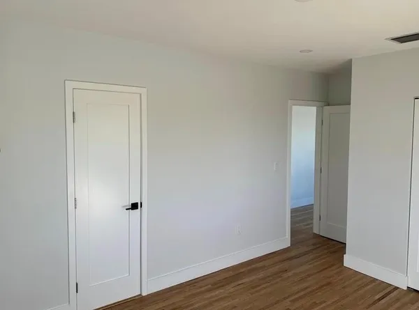a view of an empty room with wooden floor