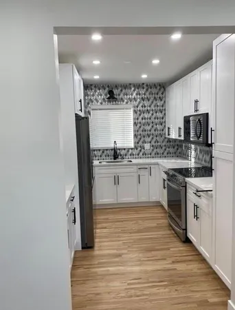 a large kitchen with stainless steel appliances granite countertop a stove and a sink